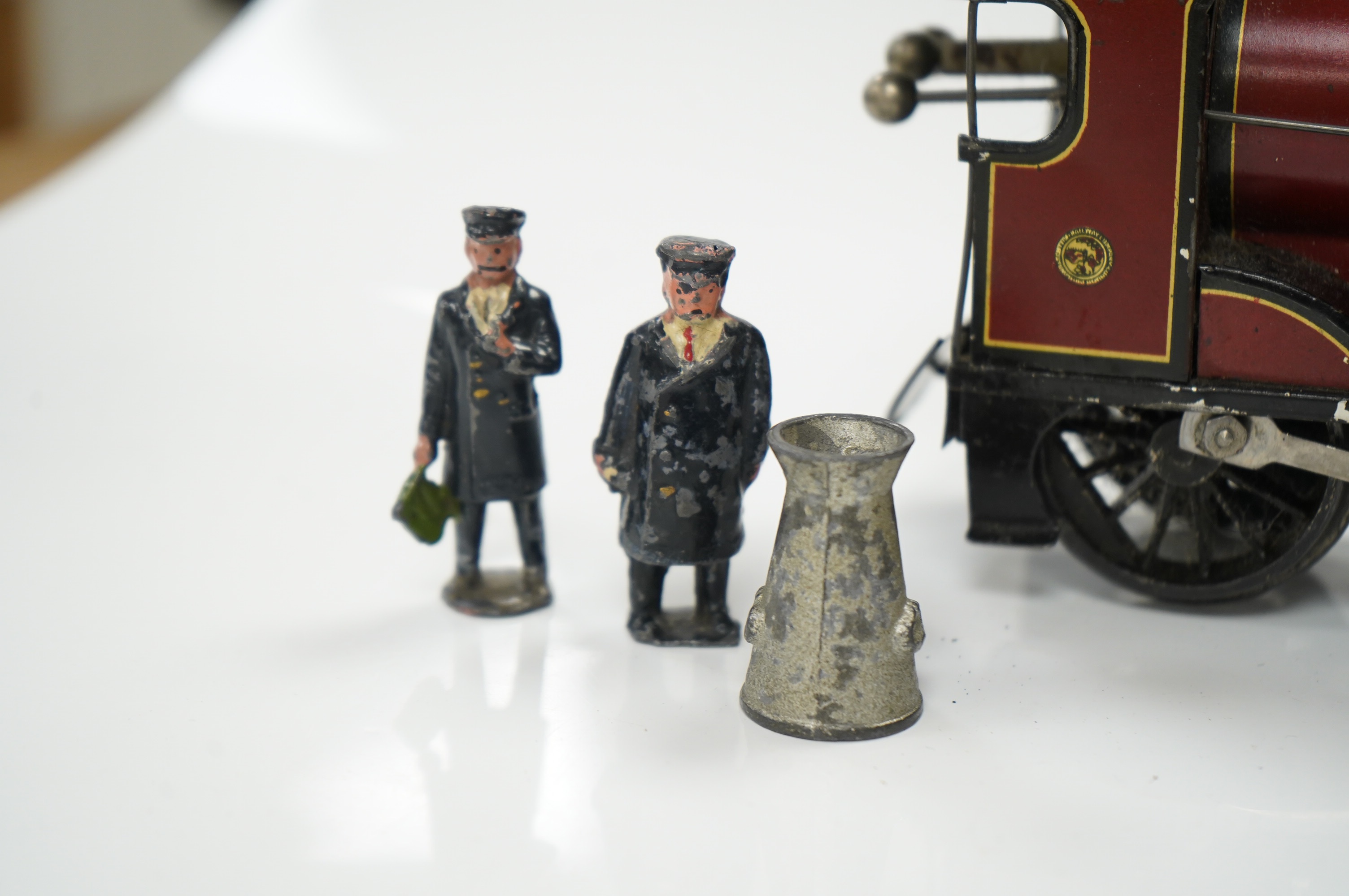 A Bassett Lowke O gauge tinplate clockwork 4-4-0 tender locomotive (missing tender), Duke of York, together with four Crescent/Britains lead railway figures and a milk churn. Condition poor to fair.